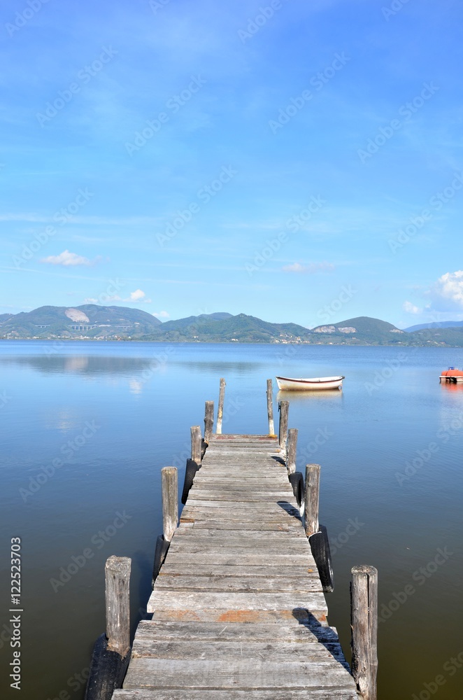 Fototapeta premium Wood pier and little boat on a lake