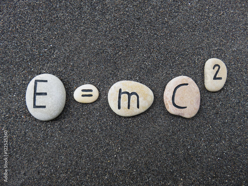 E=mc2 Theory of relativity on carved stones over lava sand  photo