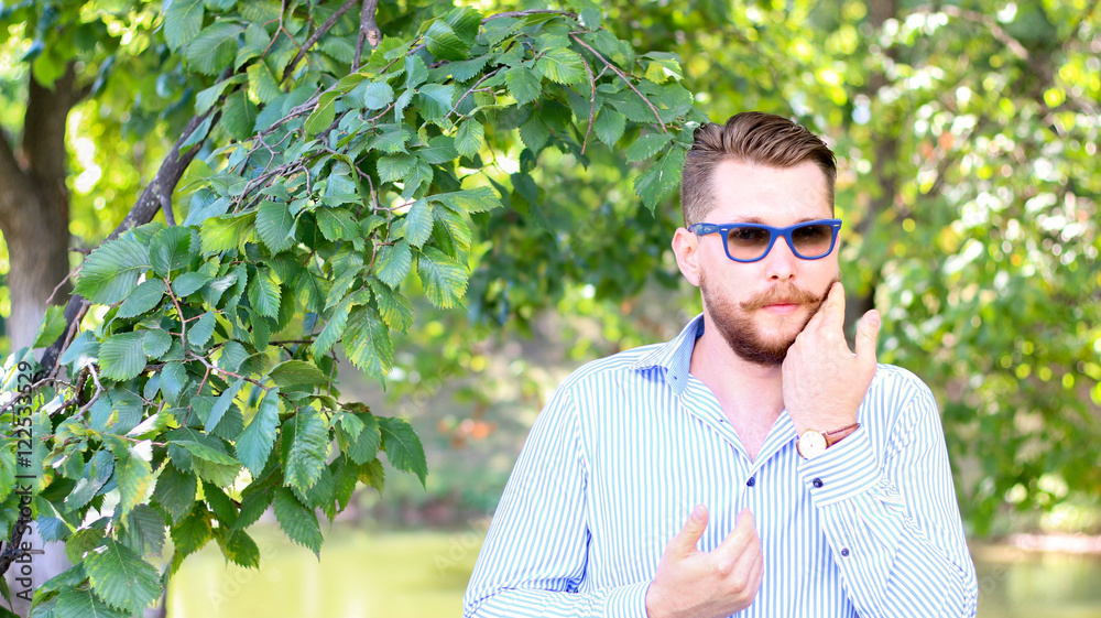Portrait of a bearded man in blue sunglasses and a shirt Portrait of a bearded man in blue sunglasses and a shirt