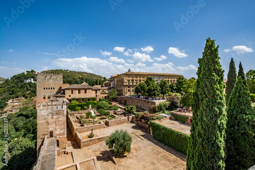 View of the Nasrid Palaces (Palacios Nazaríes) and the Palace of Charles V in Alhambra, Granada on a beautiful day, Spain 