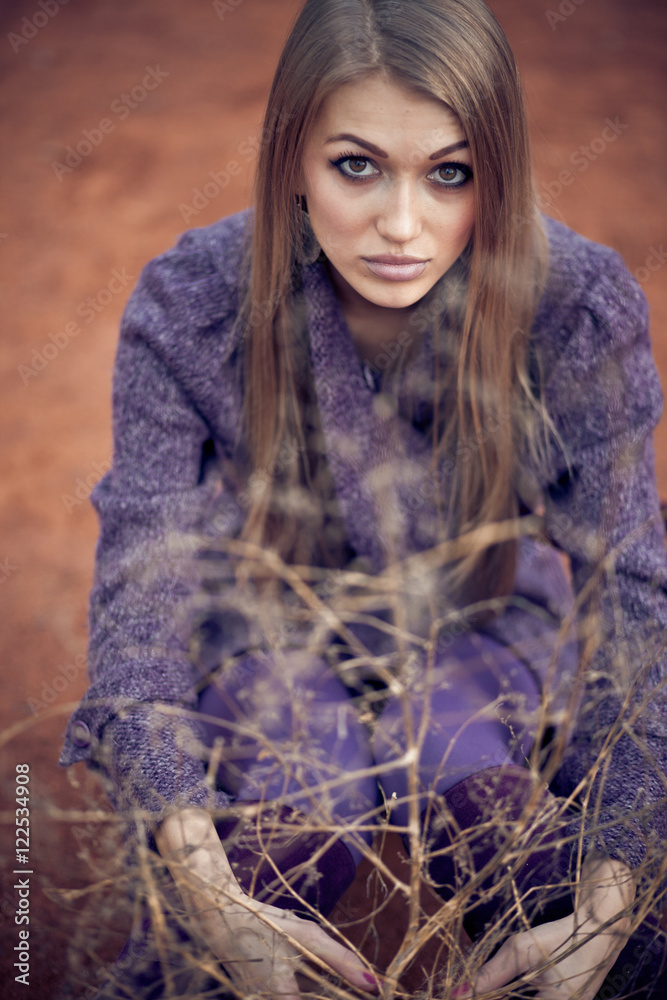Girl with deep hazel eyes looks over dry branches Girl with deep hazel eyes looks over dry branches