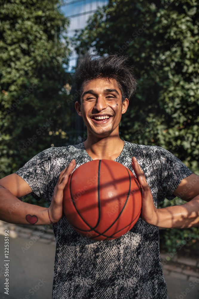 Smiling young man passing basketball