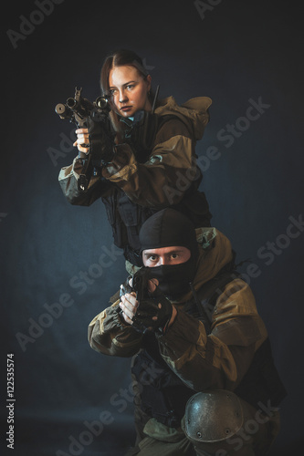 Man and woman in the images of a members of the special forces division with assault rifle in blue light. Russian police special force - Special Rapid Response Unit or SOBR (Spetsnaz).