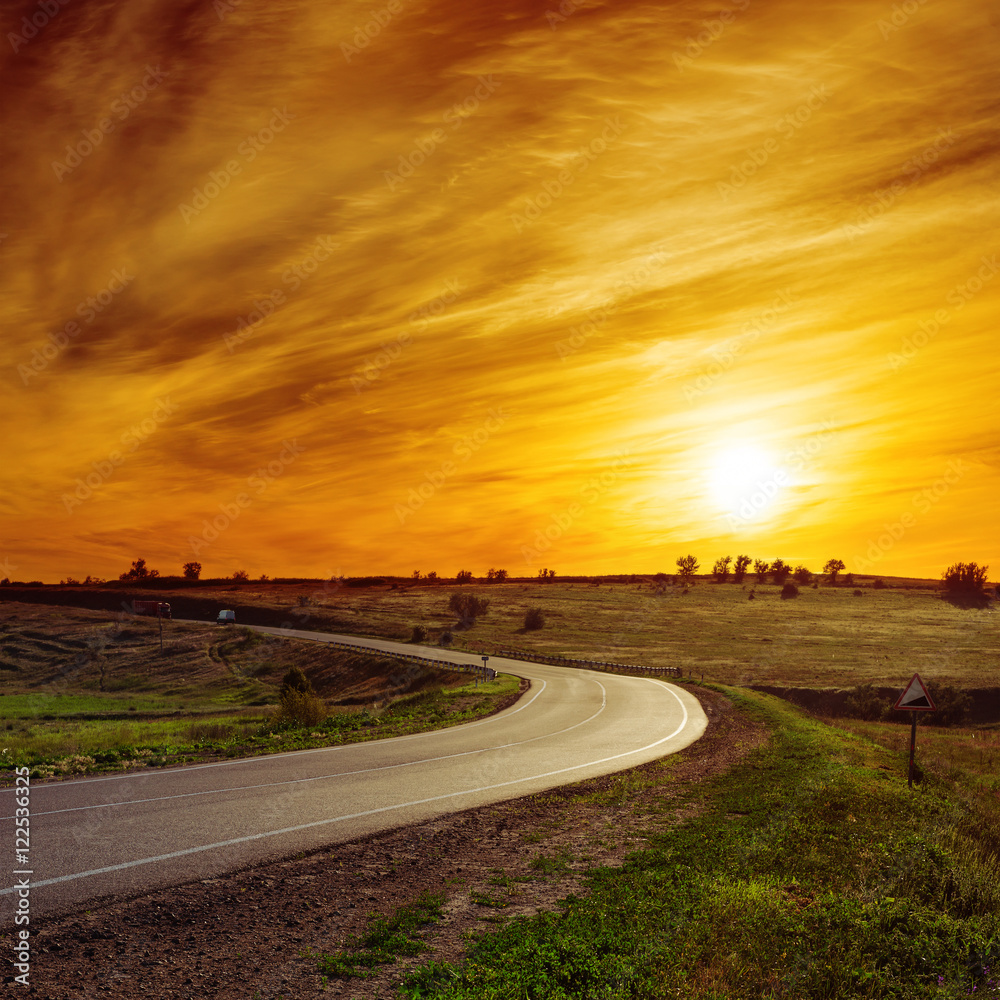 Obraz premium sun in orange sunset over asphalt road
