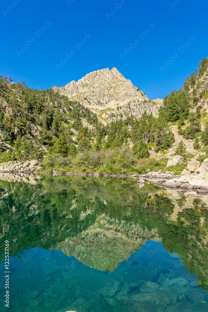 Reflection of a mountain in little lake. ( St.Maurici National Park, Catalonia, Spain)