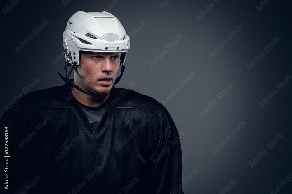 Naklejka premium Portrait of hockey player on grey background.