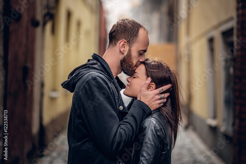 Positive bearded male kissing cute brunette female.