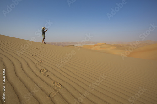 Man looking through spyglass in a desert