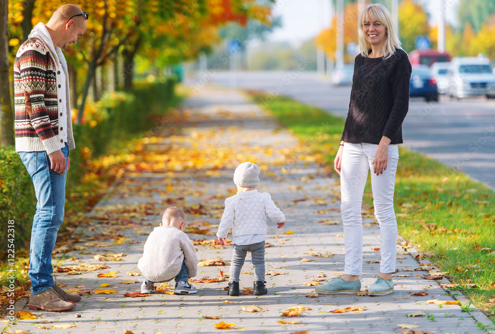 Fototapeta premium The happy family walks in the city autumn park