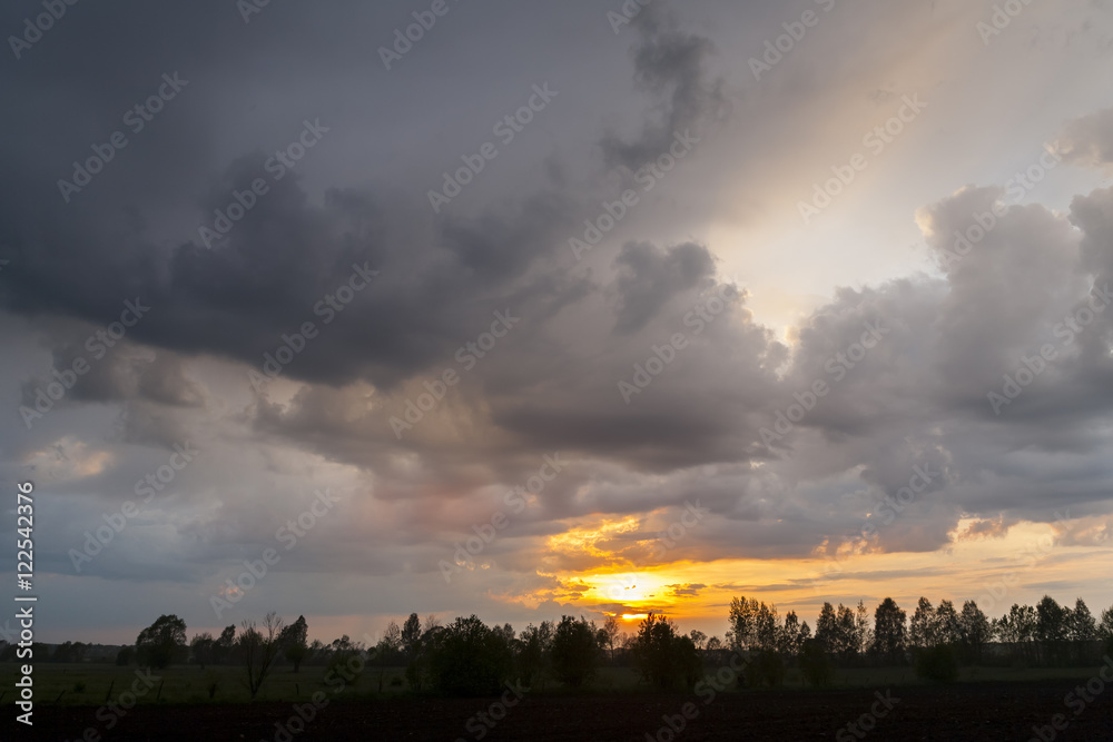 Sunset on a background of storm clouds. Bad weather, rainy weather.
