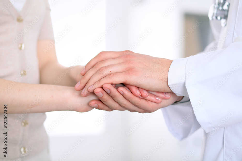 Hand of doctor reassuring her female patient Hand of doctor reassuring her female patient