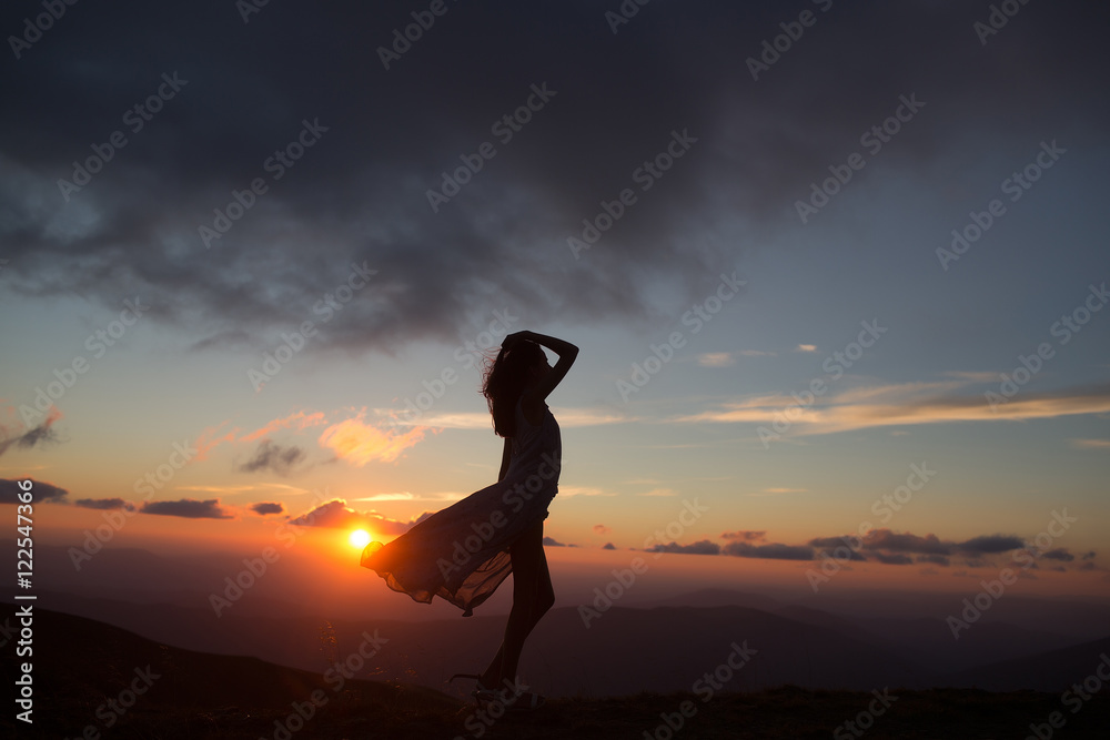 woman at sunset or sunrise in mountains