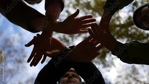 group of young place their hands together in the center of a circle