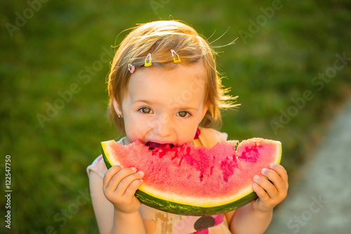 girl eating red watermelon outdoor