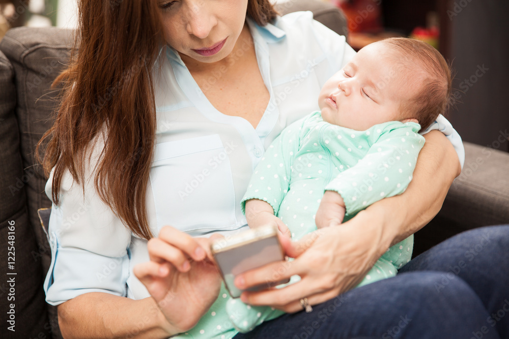 Using smartphone and holding a baby