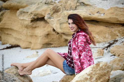 beautiful girl with colorful windbreaker by the sea