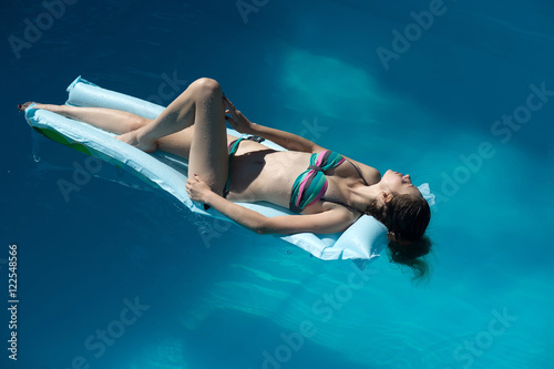 Sexy woman tanning in pool
