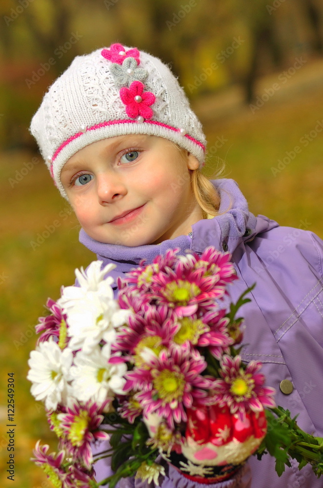 child standing with flowers in the park