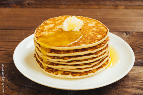 Stack of tasty pancakes with butter and honey for breakfast