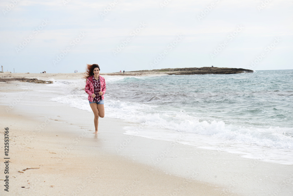 beautiful girl with colorful windbreaker running on the beach beautiful girl with colorful windbreaker running on the beach