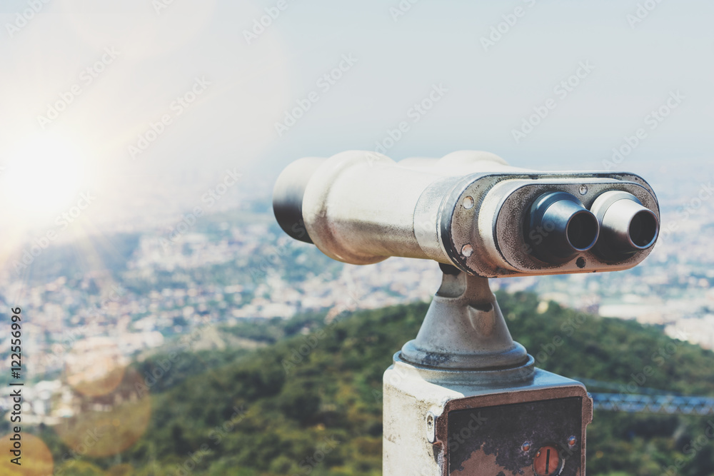 Touristic telescope look at the city with view of Barcelona Spain, close up old metal binoculars on background viewpoint overlooking the mountain, hipster coin operated in panorama observation, mockup