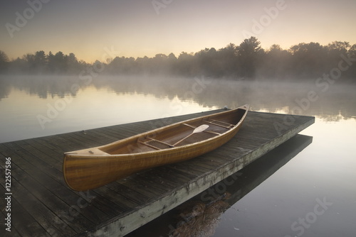 Canoe on jetty on misty lake, Muskoka, Ontario, Canada photo