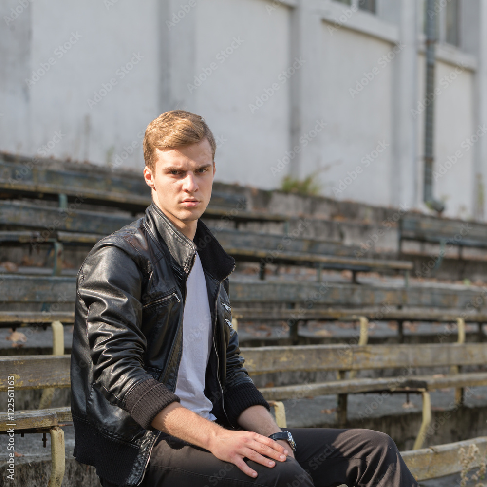young man against a wall with flowers
