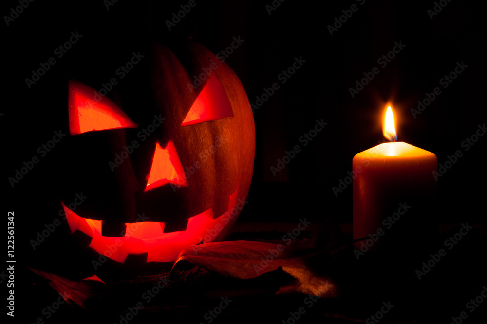 Calabaza de Halloween junto a una vela encendida Calabaza de Halloween junto a una vela encendida