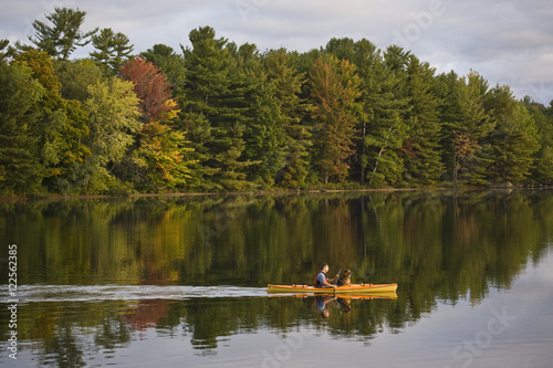 Young man kayaking with dog on Gull Lake near Gravenhurst, Ontario, Canada. photo