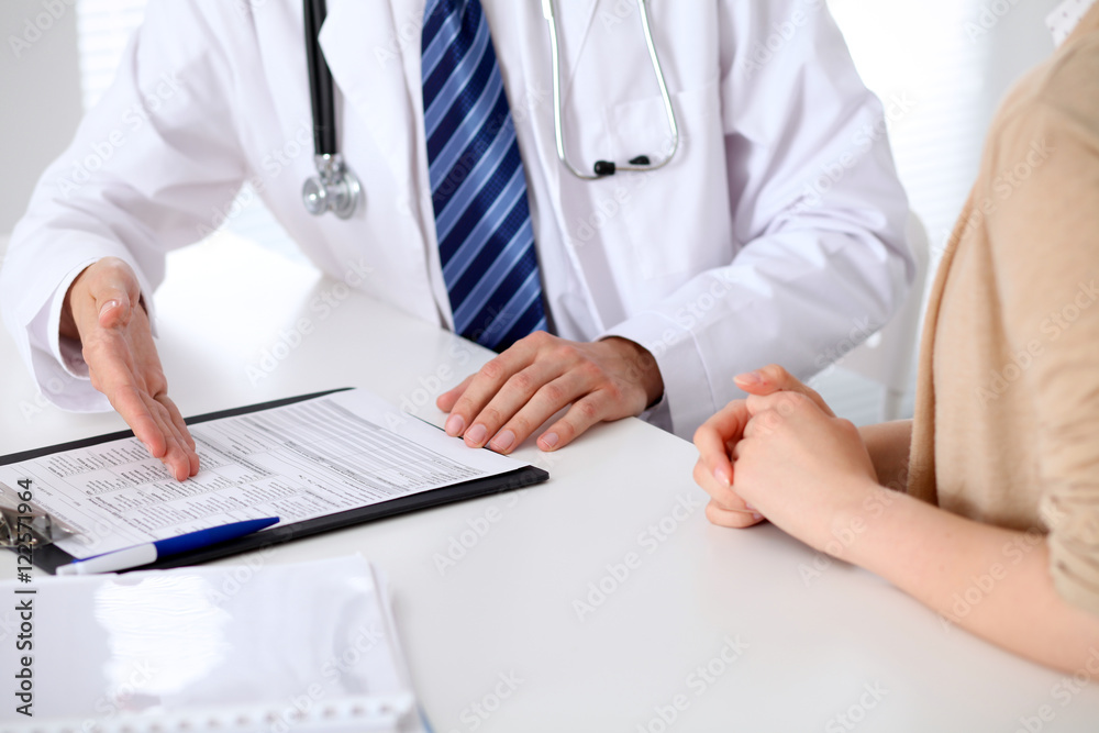 Close-up of a doctor man holding application form while consulting patient Close-up of a doctor man holding application form while consulting patient