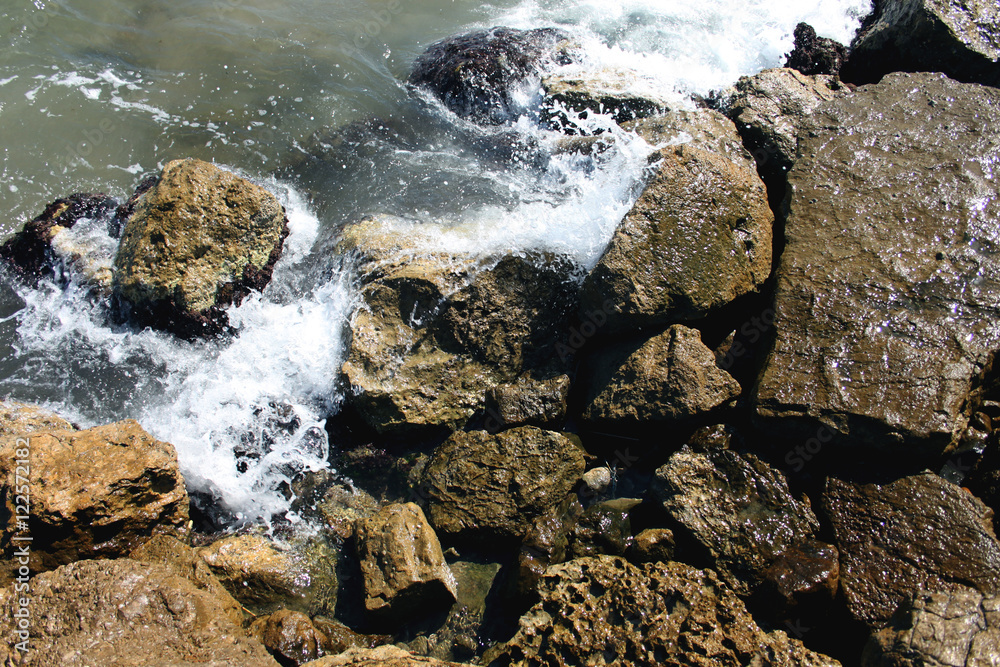 The waves of the sea beating against the sharp rocks and stones coast The waves of the sea beating against the sharp rocks and stones coast
