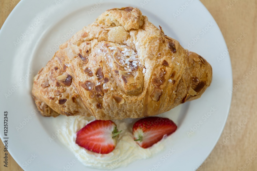 Close-up of croissant and strawberry on plate Close-up of croissant and strawberry on plate