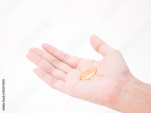 a tablet of medicine in hand on white background