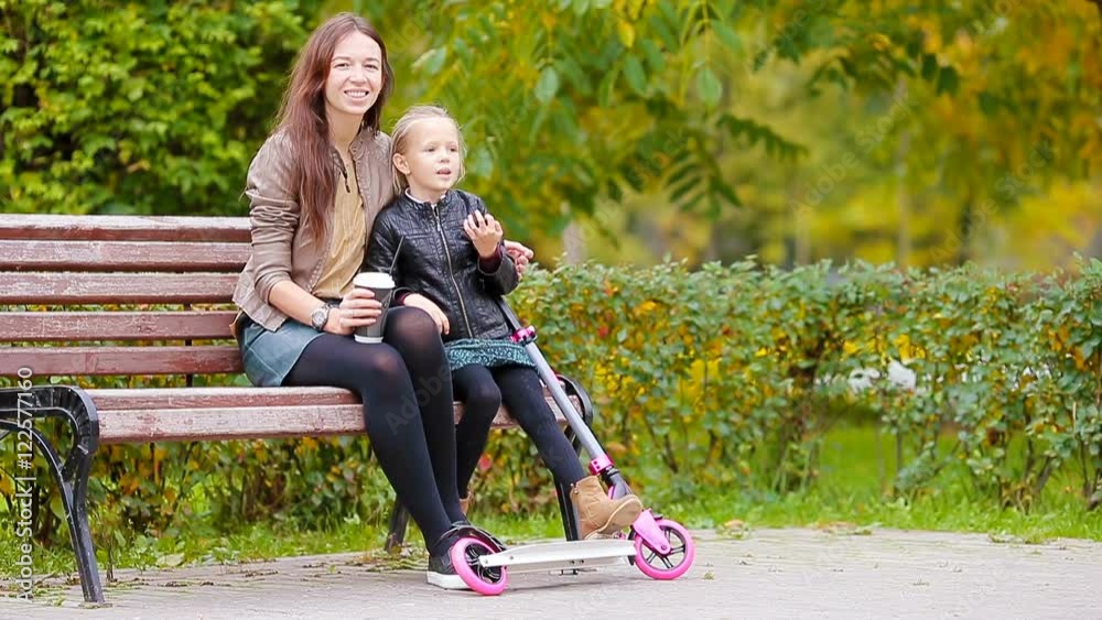 Adorable little girl with mother enjoy fall day in autumn park outdoors Adorable little girl with mother enjoy fall day in autumn park outdoors