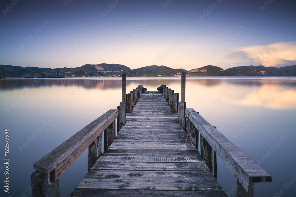 Naklejka premium Drewniane molo lub molo na niebieski zachód słońca nad jeziorem i niebo refleksji na