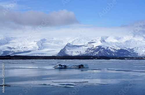 ice sheet on the water with snow mountain background © augustcindy