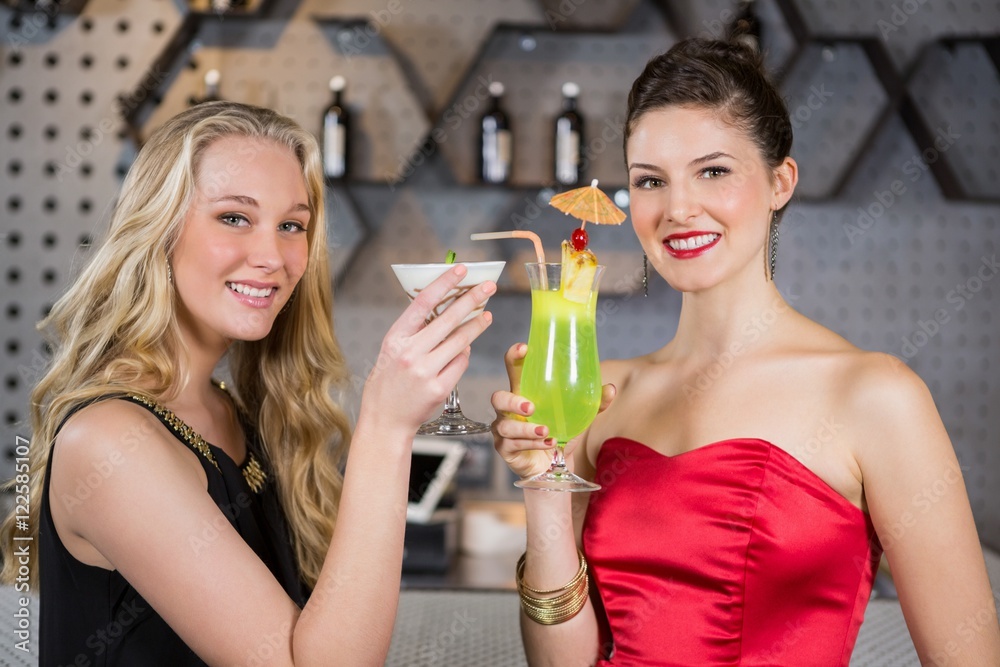 Female friends holding glass of cocktail in bar Female friends holding glass of cocktail in bar