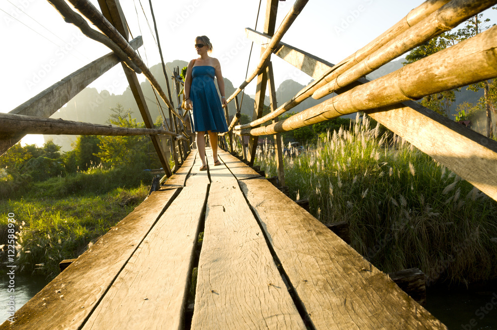Carrying groceryies over a bridge in Vang Vieng, Laos