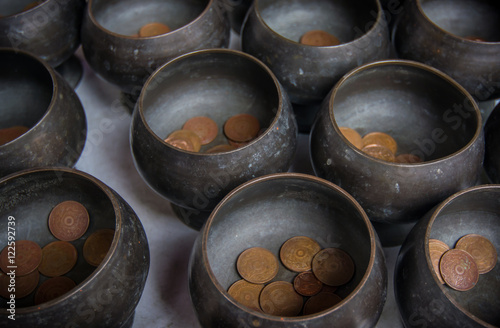Monk’s alms bowl and Thai coin donated for happiness and good luck, Thailand.