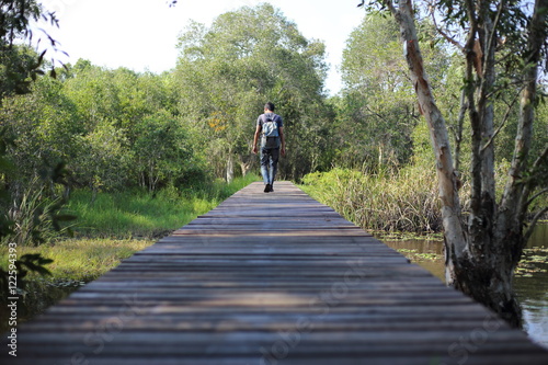 Man walking on a wooden bridge