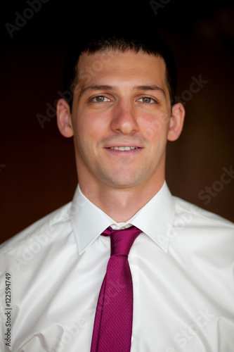 Portrait of smiling man in white shirt and pink tie