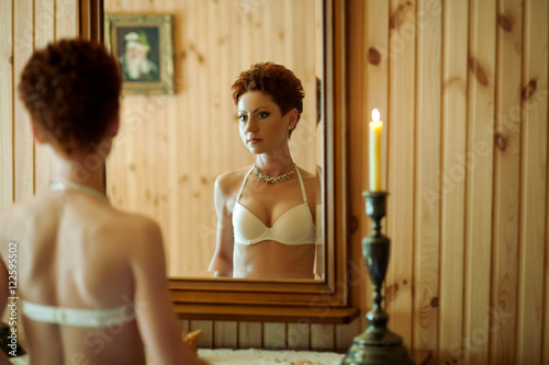 Принти на полотні Seductive short-haired bride in white lingerie watches herself i