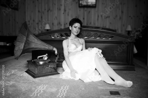 Black and white photo of bride sitting in lingerie behind the gr