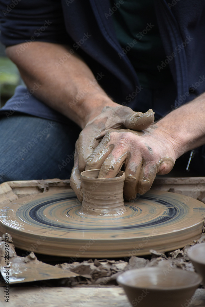potter creating a ceramic of clay on the potter's wheel in the pottery