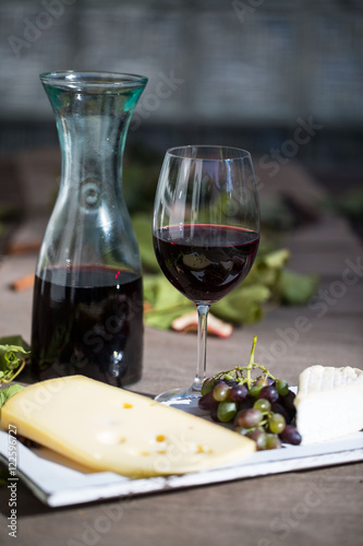 Weinkaraffe mit einem Glas Rotwein und Käse