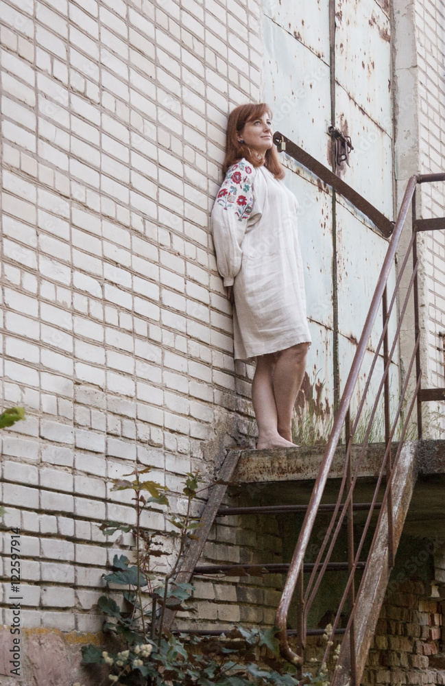 Woman in linen dress posing in an old industrial building