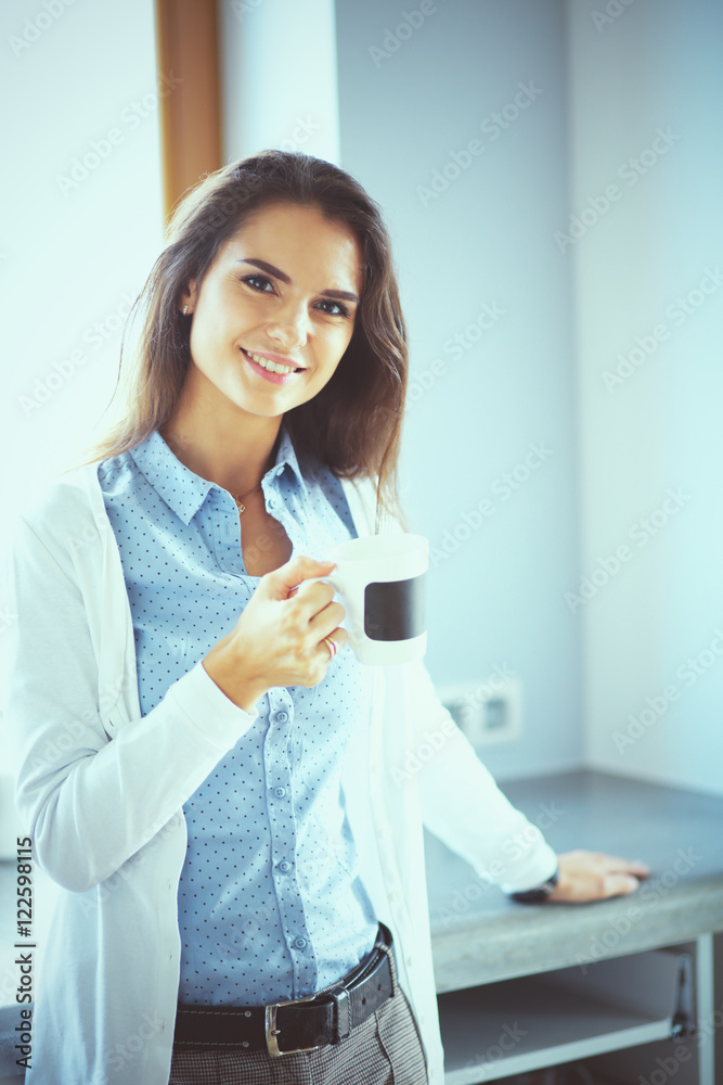 Happy woman drinking tea in the kitchen at home Happy woman drinking tea in the kitchen at home