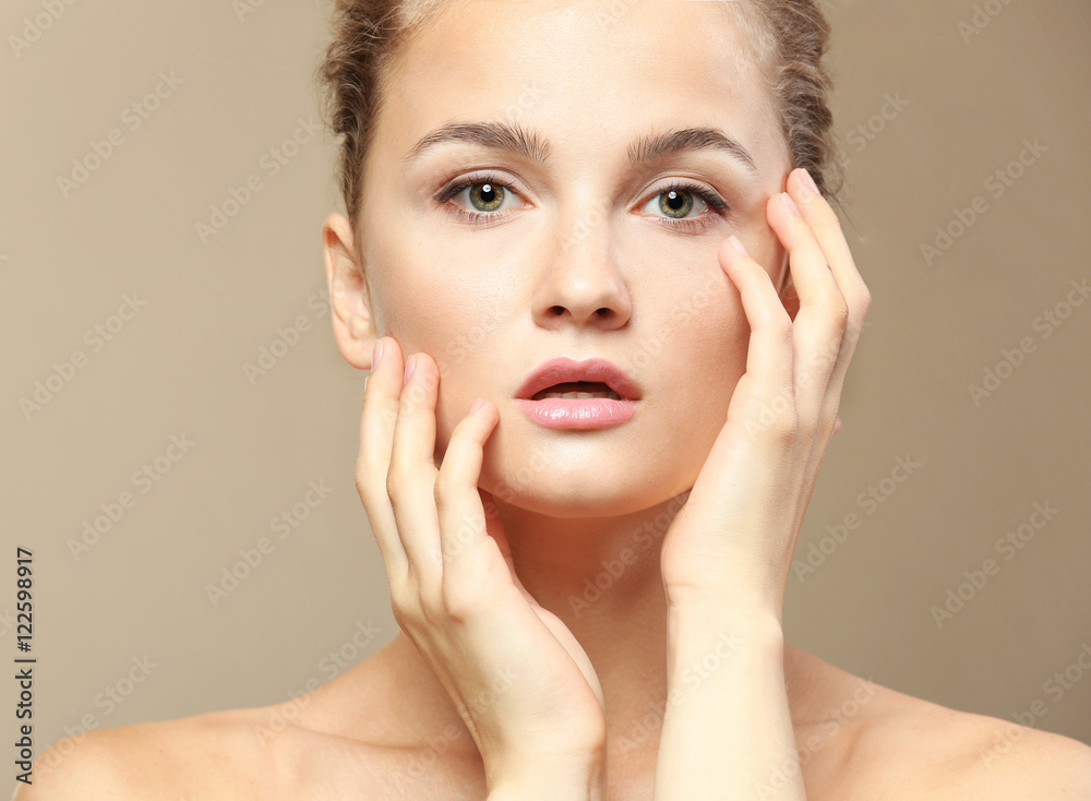 Portrait of beautiful young woman on color background