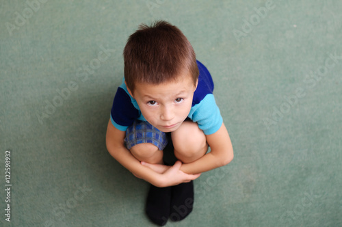Little boy looking up sitting folding