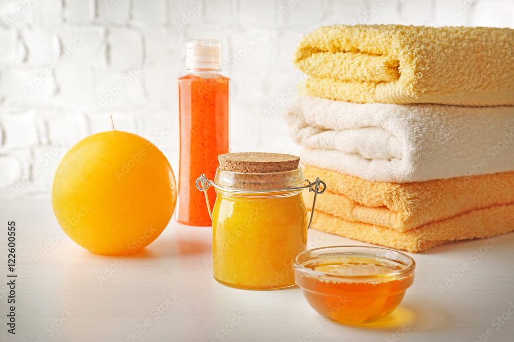 Spa concept. Natural facial mask with honey and pile of towels on white table Spa concept. Natural facial mask with honey and pile of towels on white table